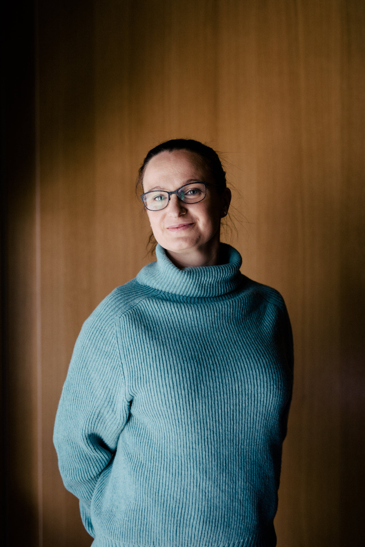 Shipitin työntekijä Nainen hymyilee kameralle vaaleansinisessä villapaidassa
